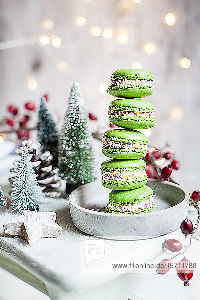 Stapel grüner Makronen und Weihnachtsschmuck