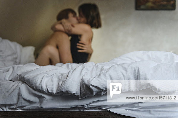 Couple hugging and kissing on bed