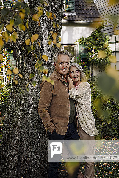 Älteres Ehepaar im Herbst im Garten ihres Hauses