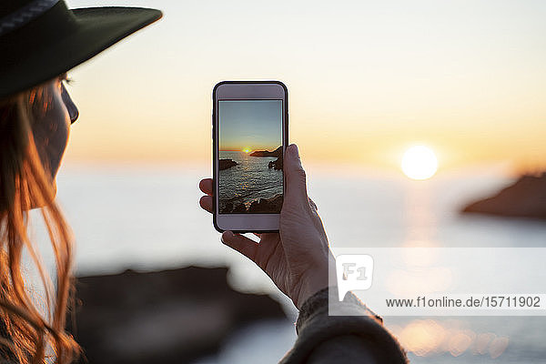 Young woman using smartphone on beach during sunset  Ibiza