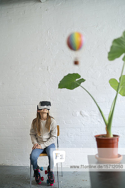 Mädchen mit VR-Brille und Heißluftballon im Büro
