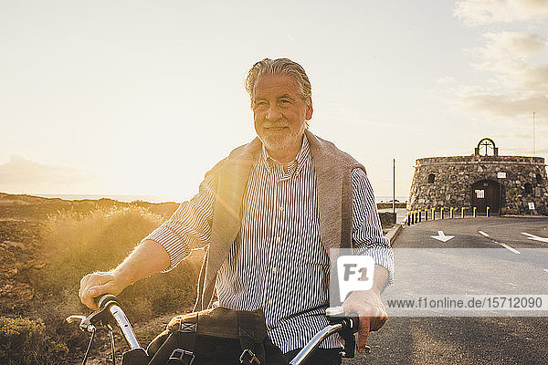 Älterer Mann auf dem Fahrrad bei Sonnenuntergang  Teneriffa