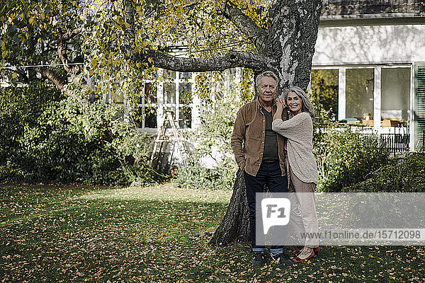 Älteres Ehepaar im Herbst im Garten ihres Hauses