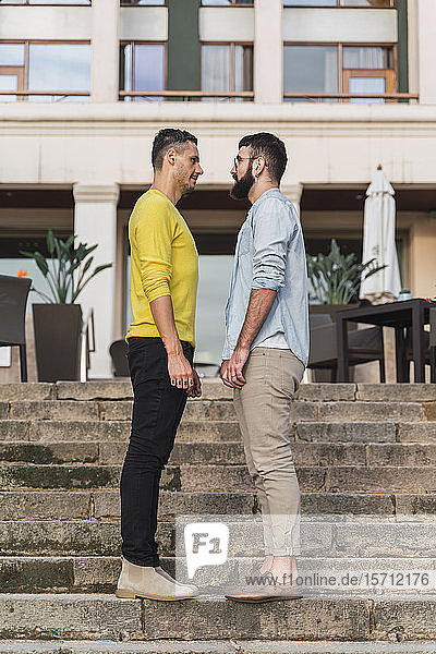 Schwules Paar steht sich auf einer Treppe gegenüber
