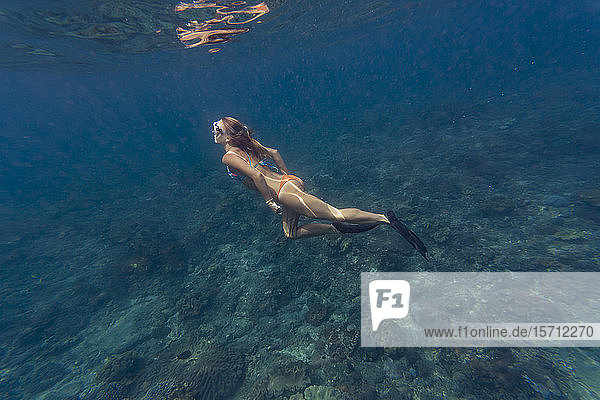 Young woman diving  Nusa Penida island  Bali  Indonesia