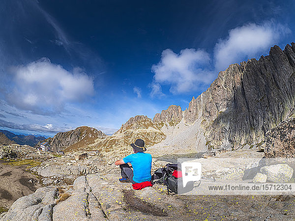 Älterer Mann macht eine Pause vom Wandern in der Berglandschaft  Fleimser Alpen  Trentino  Italien
