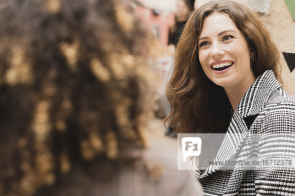 Two happy women meeting and talking outdoors in the city