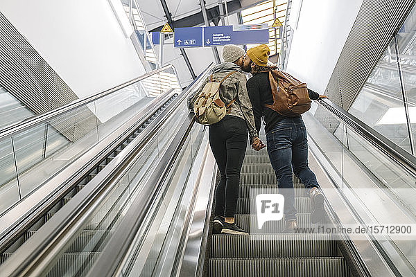 Junges Paar küsst sich auf einer Rolltreppe am Bahnhof  Berlin  Deutschland