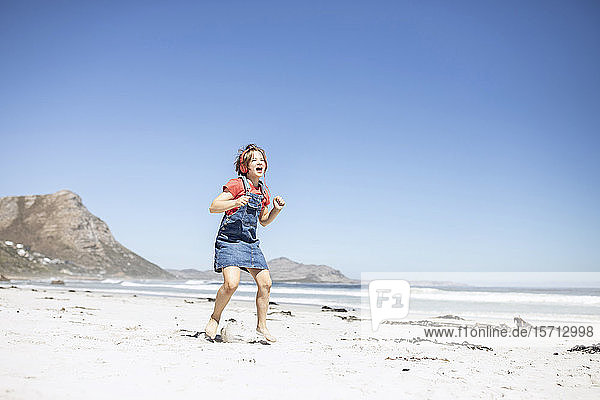 Girl with headphones singing and dancing on the beach  Cape Town  Western Cape  South Africa