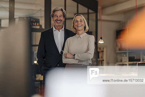 Porträt eines lächelnden Geschäftsmannes und einer lächelnden Geschäftsfrau im Amt