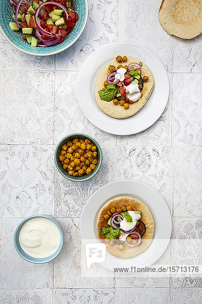 Israelischer Sabich mit Fladenbrot Auberginen Kichererbsen Zwiebeln Tomaten Gurken Joghurt und Zhug-Sauce