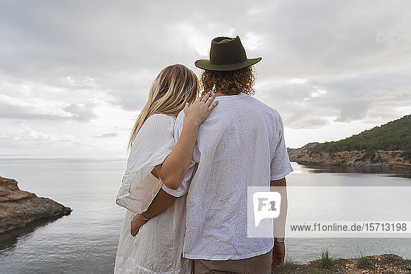 Rückansicht eines jungen Paares vor dem Meer mit Blick aufs Meer,  Ibiza,  Balearen,  Spanien