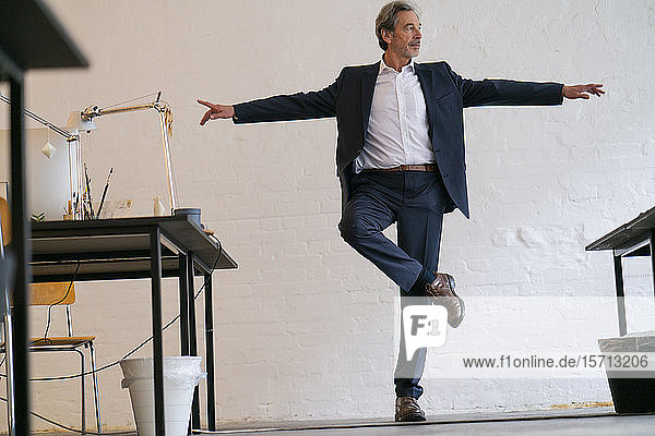 Senior businessman doing a yoga exercise in office
