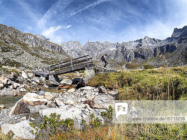 Italien  Provinz Brescia  Adamello-Alpen  Val Salarno  Parco regionale dell'Adamello  Wanderer an Holzbrücke