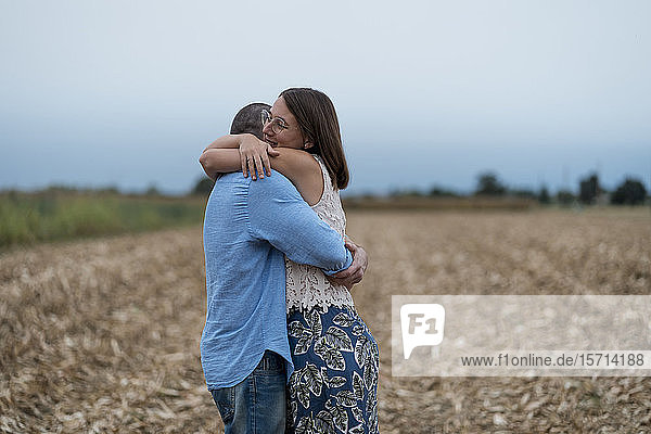 Verliebtes Paar umarmt sich auf einem Feld