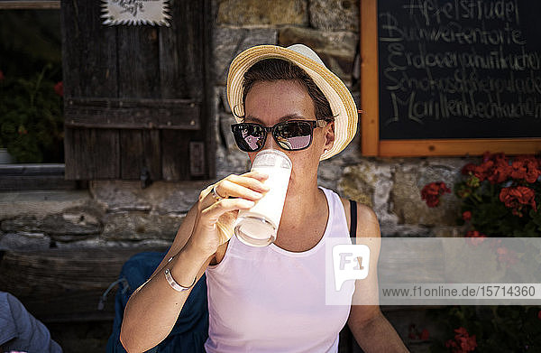Frau geniesst ein Glas Buttermilch auf einer Berghütte  Passeiertal  Südtirol  Italien