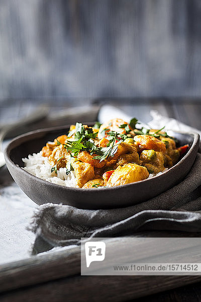 Schale mit veganem Curry mit Kartoffeln,  Karotten,  Erbsen,  Petersilie und Kürbis