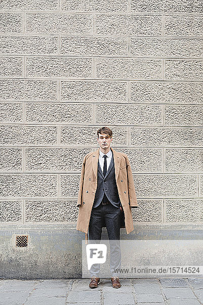 Portrait of young businessman standing on pavement