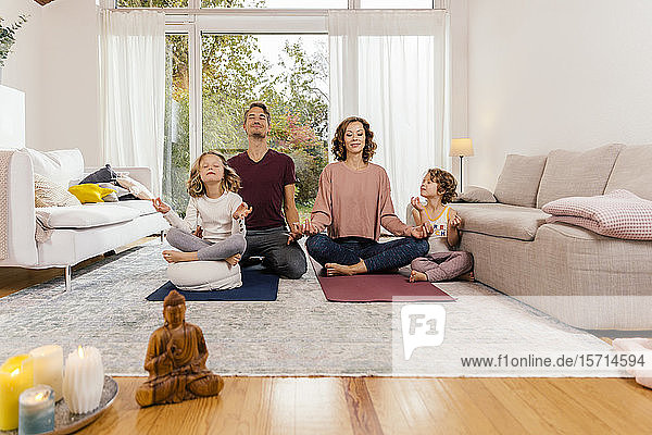 Gemeinsam meditierende Familie zu Hause