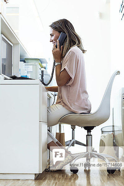 Woman talking on the phone at reception desk