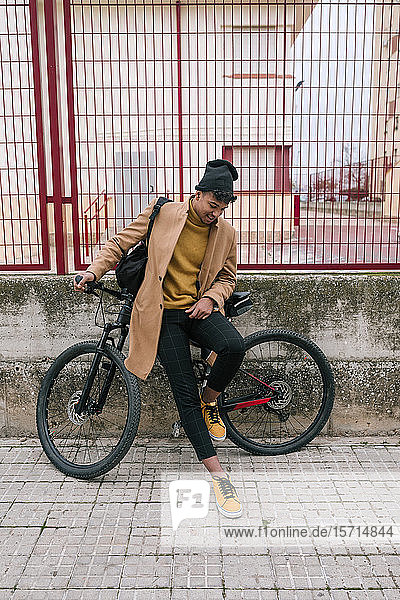 Junger Mann mit Fahrrad in der Stadt