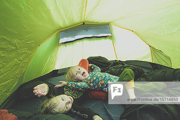 Geschwister spielen zusammen in einem Zelt