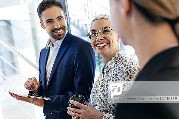Lächelnde Geschäftsleute arbeiten im Büro zusammen