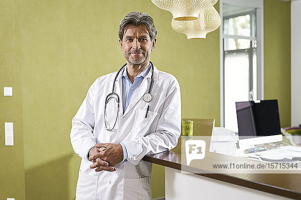 Porträt eines selbstbewussten Arztes beim Empfang in seiner Praxis