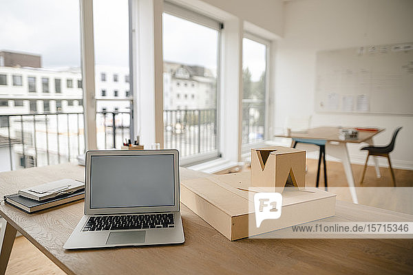 Architekturmodell und Laptop auf dem Schreibtisch im Büro
