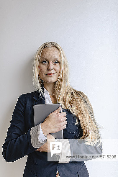 Porträt einer blonden jungen Geschäftsfrau mit Tablette in der Hand