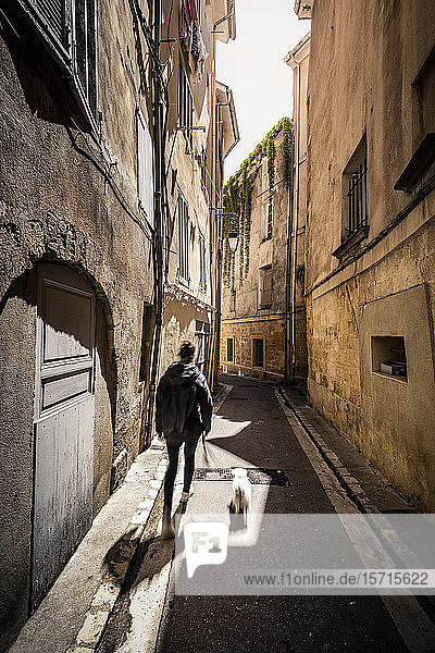 Frankreich Provence  Aix-en-Provence  Frau mit Hund beim Spaziergang auf der Straße