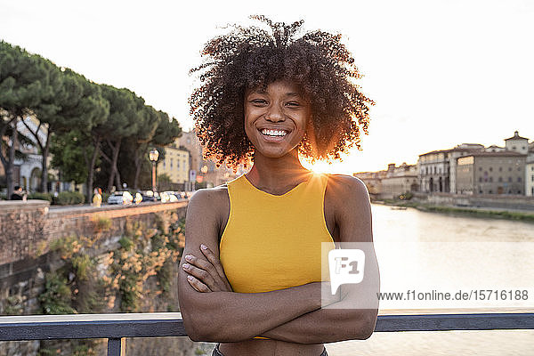 Porträt einer glücklichen jungen Frau auf einer Brücke über dem Arno bei Sonnenuntergang  Florenz  Italien