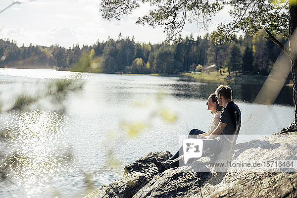 Affectionate couple sitting at the lakeside  Forstsee  Carinthia  Austria