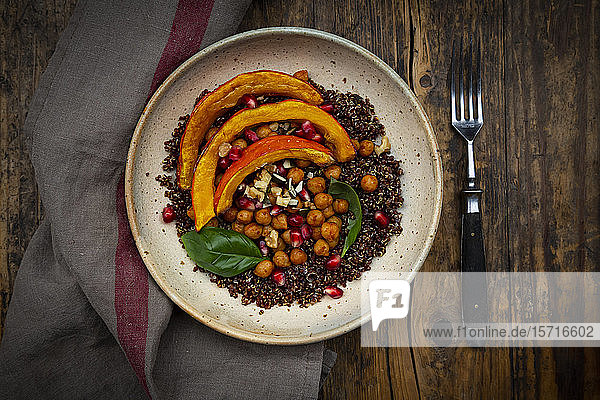 Schüssel Quinoa mit gebackenem Kürbis Kichererbsen Granatapfel Basilikum Walnüssen und Kürbiskernen