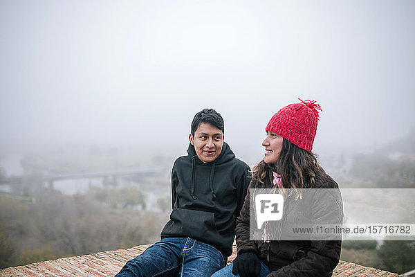 Young Mexican couple interacting on a foggy day