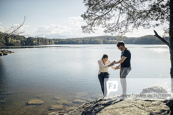 Happy couple hand in hand at the lakeside  Forstsee  Carinthia  Austria