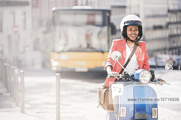 Glückliche junge Frau fährt Motorroller in der Stadt  Lissabon  Portugal