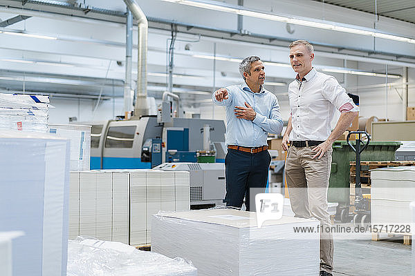Zwei Kollegen im Gespräch in einer Fabrik