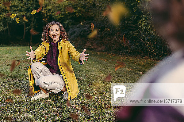 Glückliche Mutter wartet im Herbst mit offenen Armen auf ihre Tochter im Freien