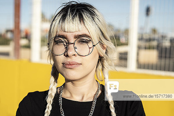 Bildnis einer jungen Frau mit gefärbten Haaren und einer Brille mit Metallrahmen