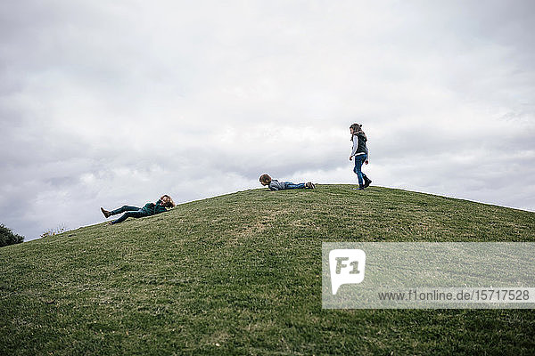 Drei Kinder spielen auf einem Hügel