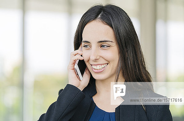 Porträt einer glücklichen Geschäftsfrau beim Telefonieren