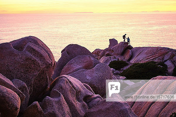 Italien  Provinz Sassari  Santa Teresa Gallura  Silhouette eines Paares  das von den Felsblöcken des Kap Testa herabsteigt