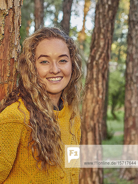 Porträt einer glücklichen jungen Frau in einem Kiefernwald