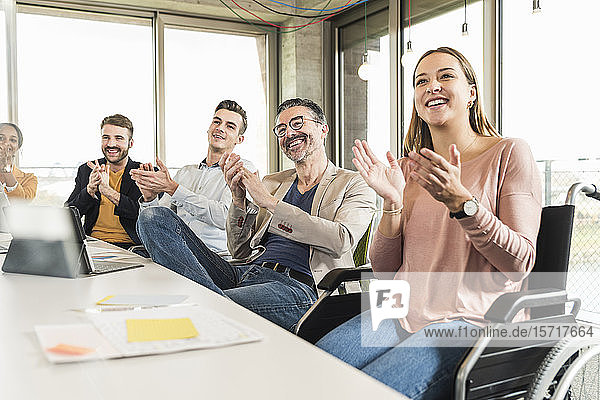 Glückliche Geschäftsleute applaudieren während einer Sitzung im Sitzungssaal