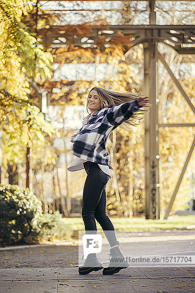 Glückliche Frau tanzt im Herbst im Freien