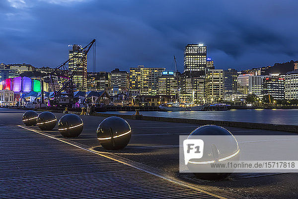 Neuseeland  Wellington  Lichtkugeln entlang des Hafens bei Nacht mit beleuchteter Stadtsilhouette im Hintergrund