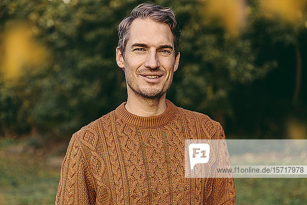 Porträt eines lächelnden Mannes im Herbst im Freien