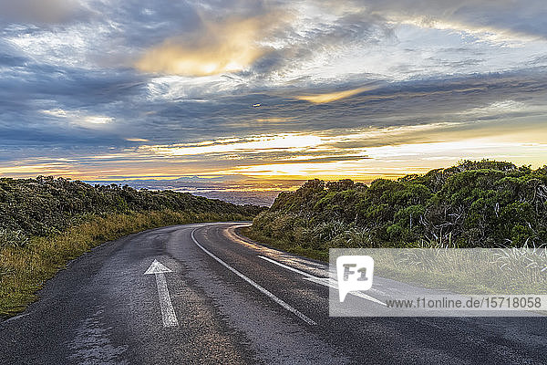 New Zealand  Clouds over empty asphalt road in Egmont National Park at dusk