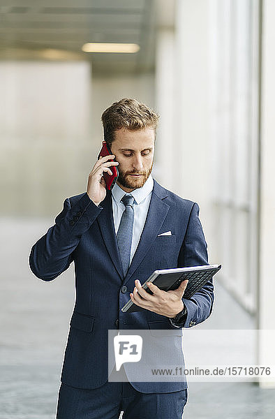 Businessman holding tablet talking on the phone